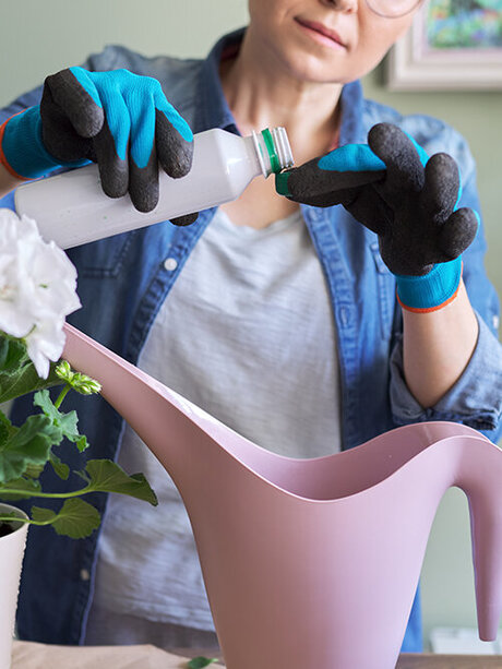 Blumen-Risse, Pflanzen, Pflanzenzubehoer, Pflanzenduenger, Blumenduenger, Frau-mischt-Fluessigduenger-in-Giesswasser